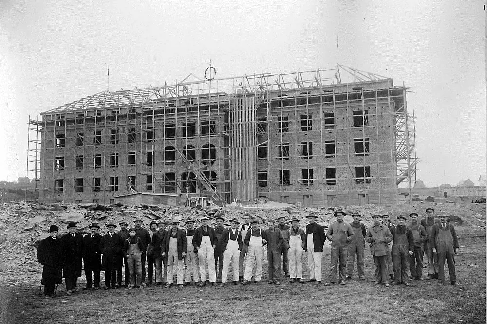 En gruppe mennesker som står foran en bygning