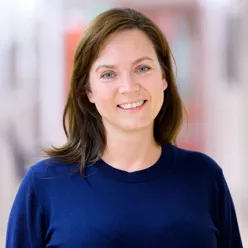 En kvinne som smiler til kameraet