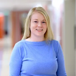 En kvinne som smiler til kameraet