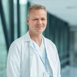 En mann iført hvit skjorte og stetoskop