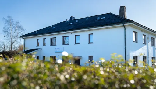 A house with a field of flowers in front of it