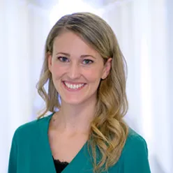 Kvinne smiler mot kamera