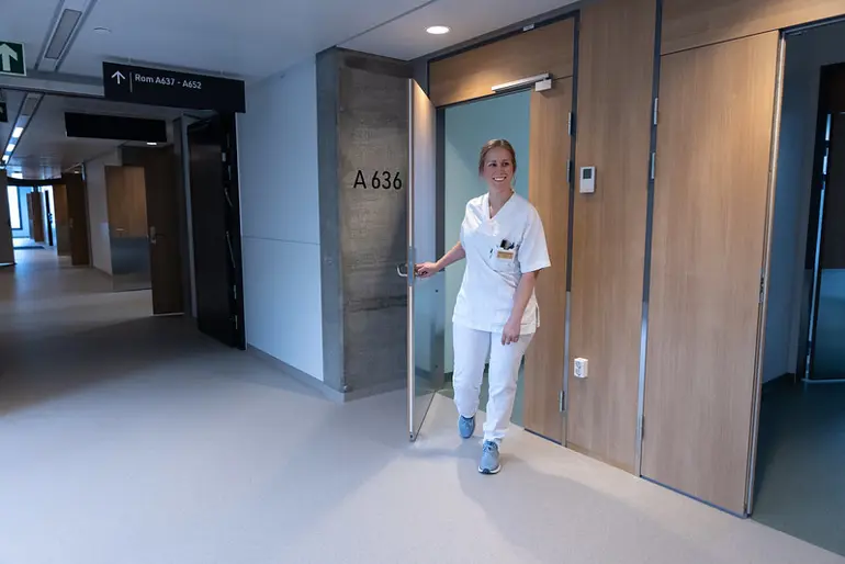 En sykepleier som står i en gang
