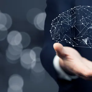 Over hånden er det illustrert en menneskehjerne.