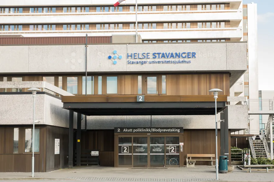 Betongbygg med glasskyvedør. Foto.