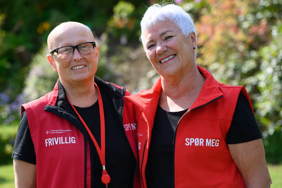 Anette Hauge og Svanhild Gaupås i frivilligkorpset på SUS med røde vester. Foto.