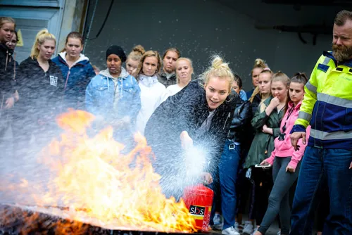 En gruppe mennesker som står rundt et bål