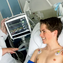 Lege som besøker et barn ved sengen. Foto.