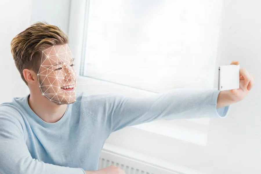 Mann som tar et bilde av seg selv med telefonen.