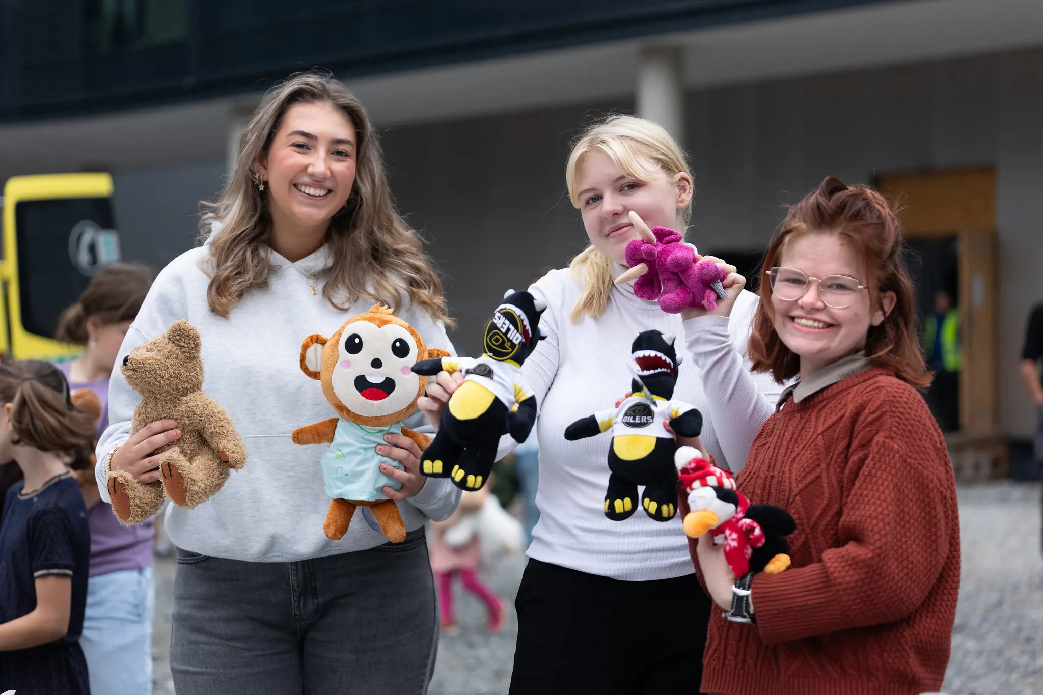 Tre kvinner fra ungdomsrådet holder bamser på familiedag på det nye sykehuset.