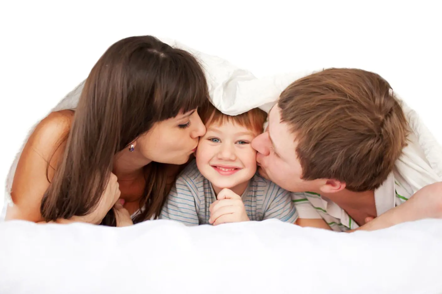 Et barn ligger mellom to voksne og får et kyss på hvert kinn