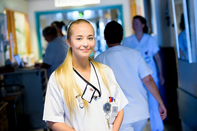 Ung kvinnelig sykepleier smiler til kameraet.
