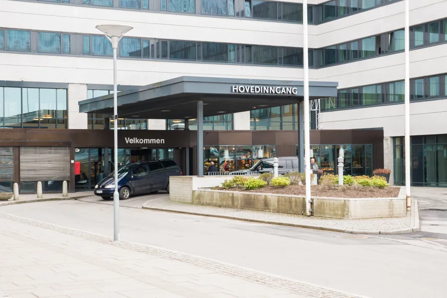 Betongbygg med inngangsdør. Foto.